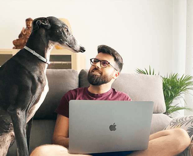 Manu con su galgo, trabajando desde el sofá